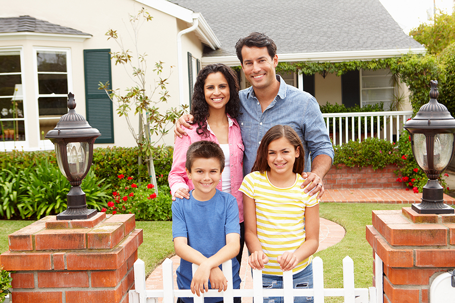 happy family standing in front of home after obtaining a home equity line of credit