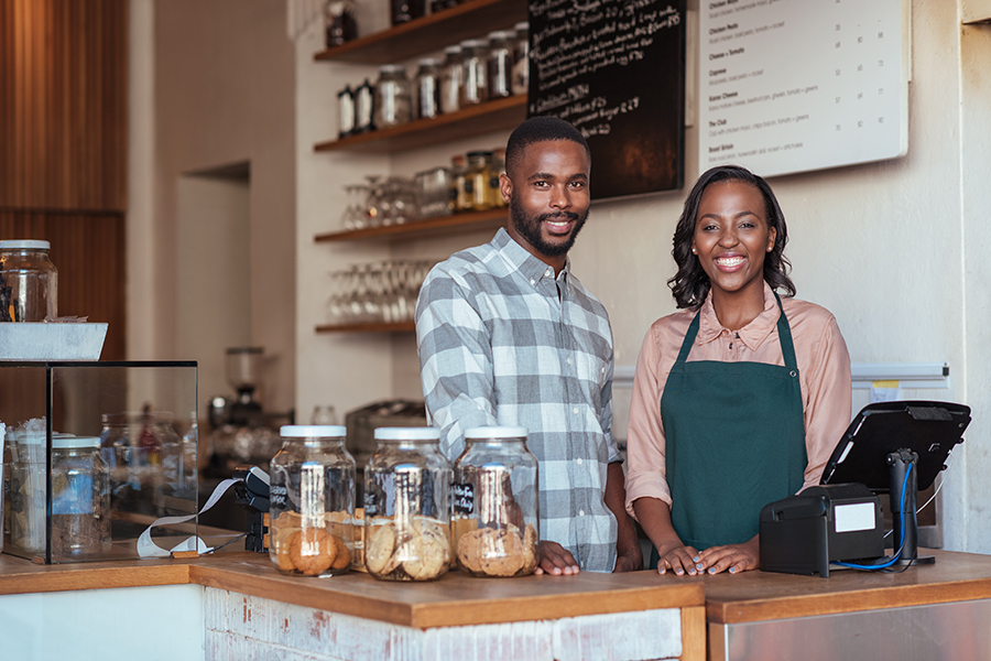 Georgia business owners smiling at coffee shop after opening certificate of deposit account