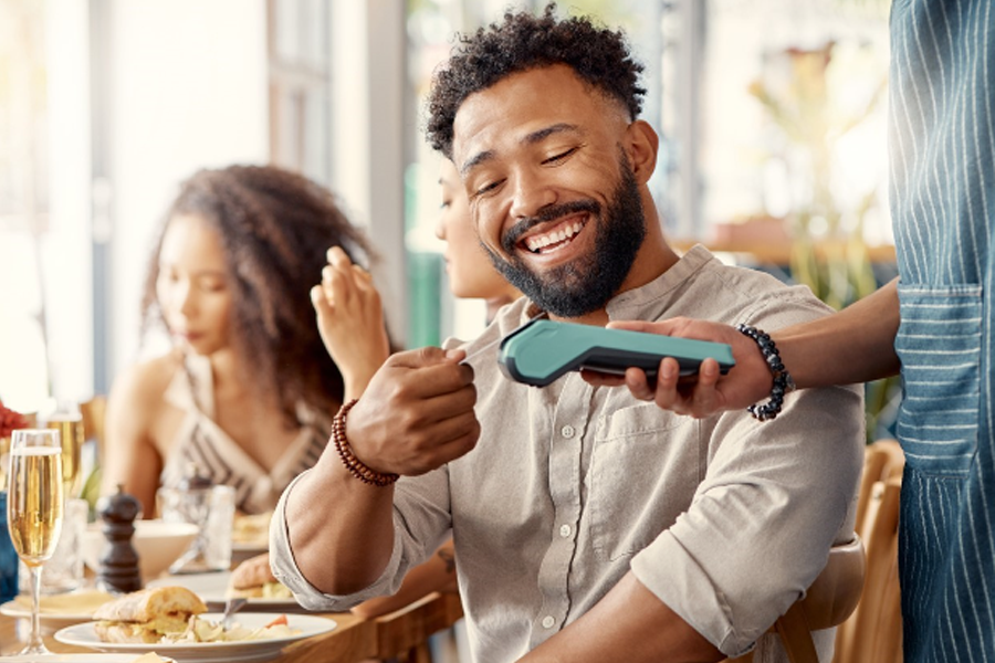 Man using his debit card while dining out