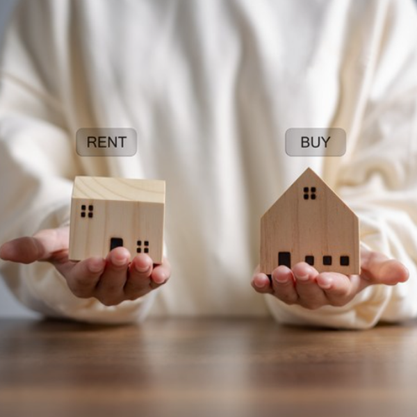Buying vs Renting image where person is holding wooden two houses