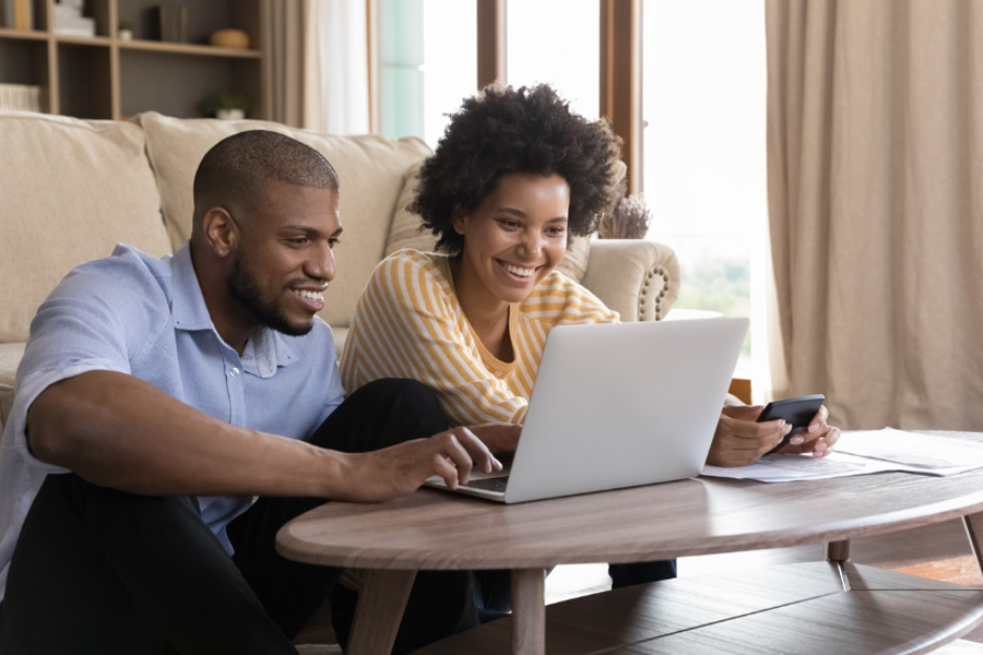 couple paying bills online from the couch