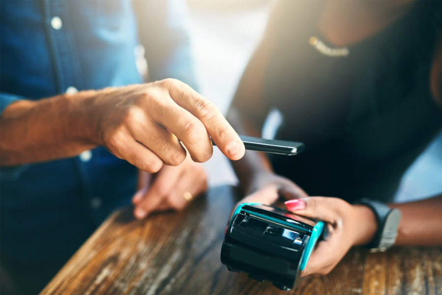 man using digital wallet to pay bill at restaurant