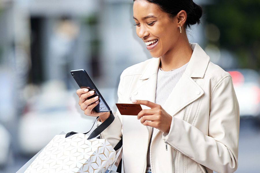 woman holding a shopping bag shopping with her debit card